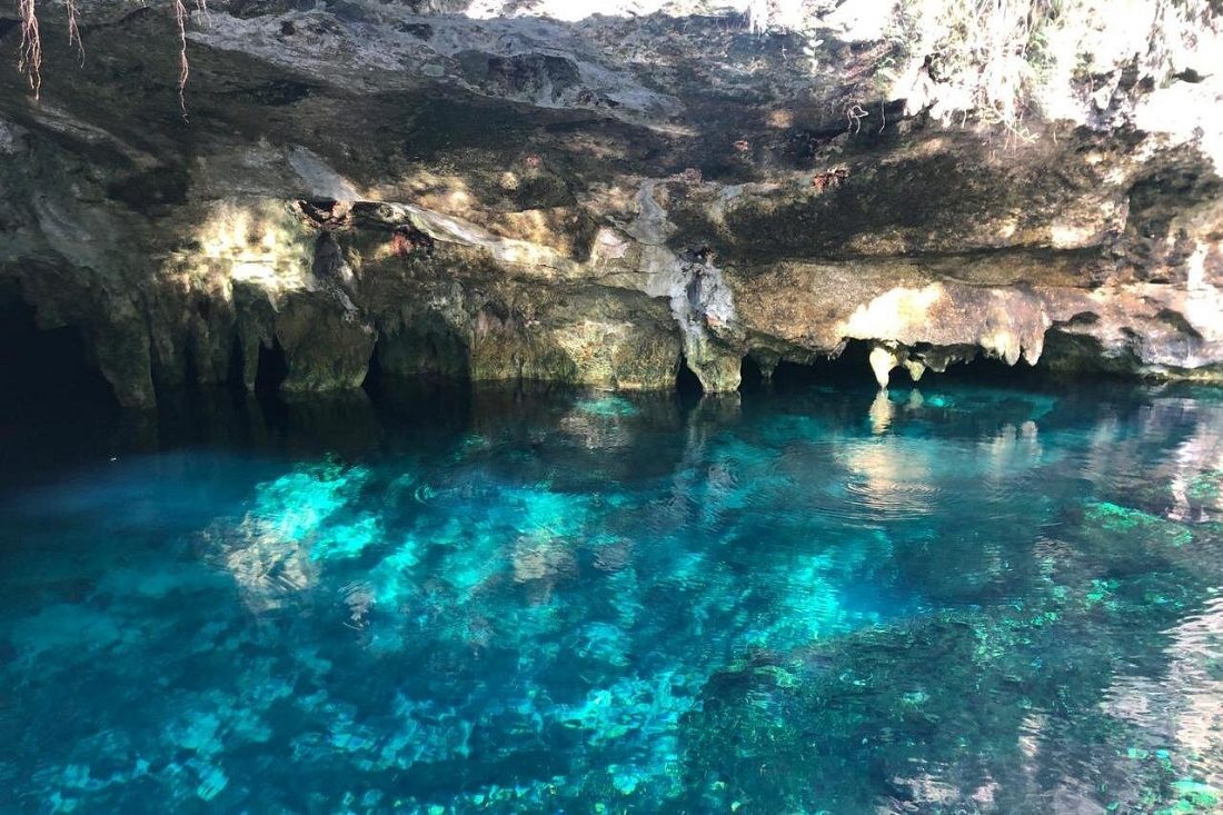 Wooden walkways and clear pools inside the half-open cavern at Gran Cenote near Tulum