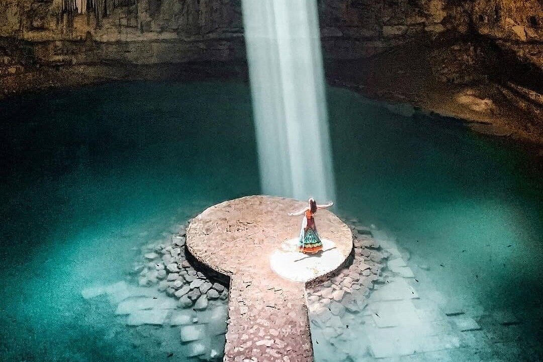 The shaft of daylight falling through the roof of Cenote Suytun onto the circular stone platform