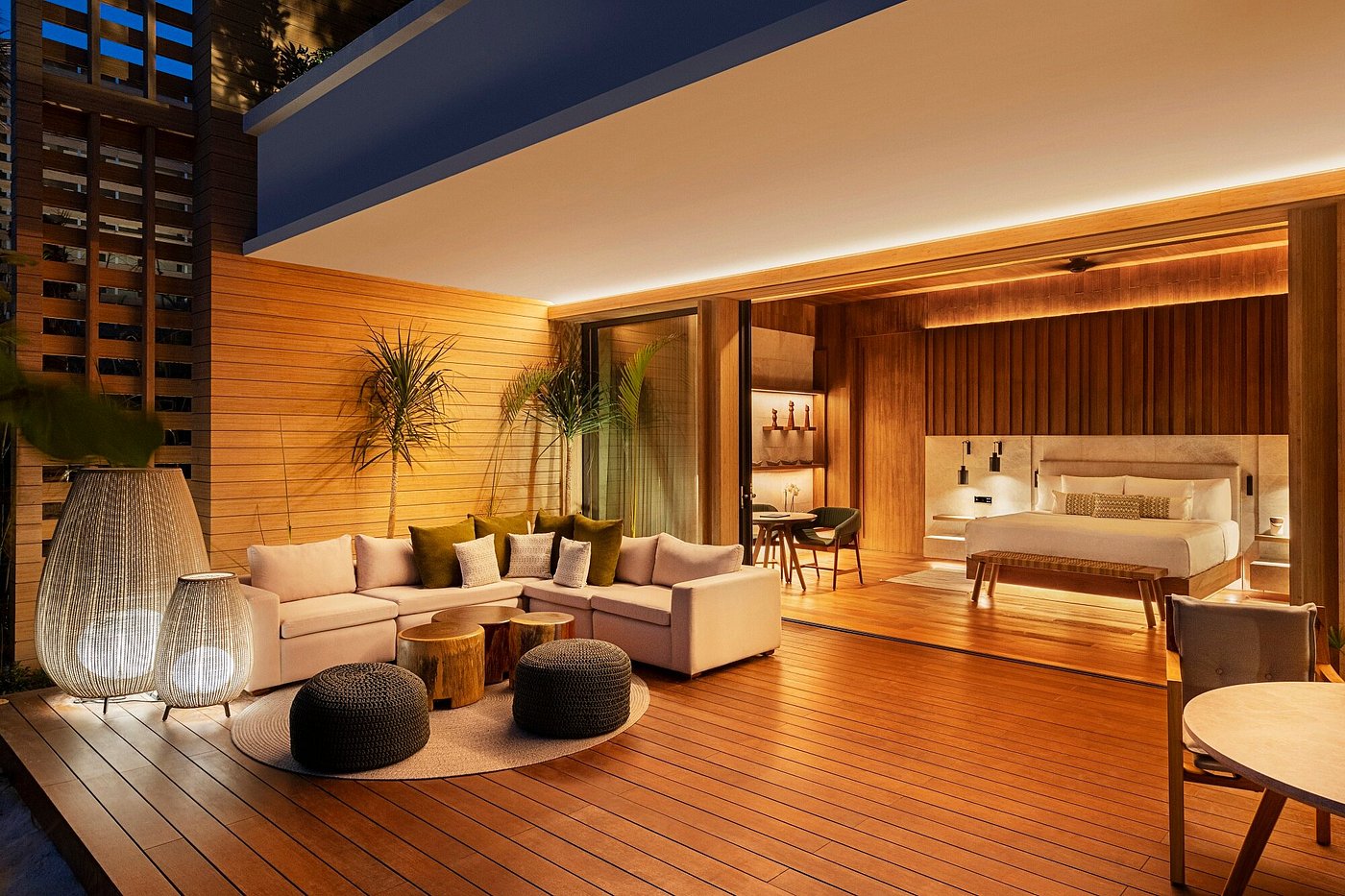 A timber-lined bedroom at Banyan Tree Mayakoba opening fully to a beach and sea view