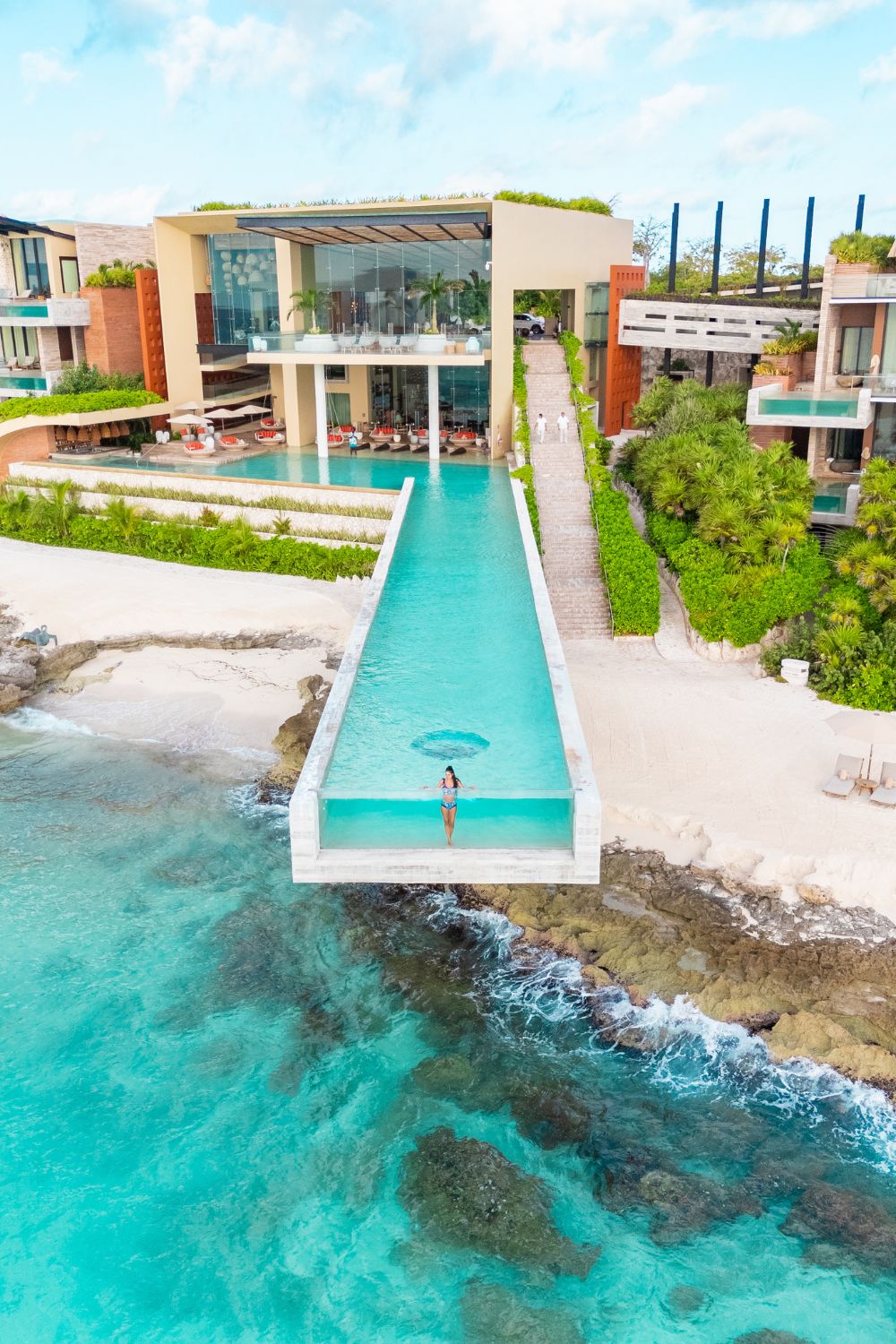 The long glass-fronted cantilevered pool at La Casa de la Playa reaching out over the rocky shore toward the sea