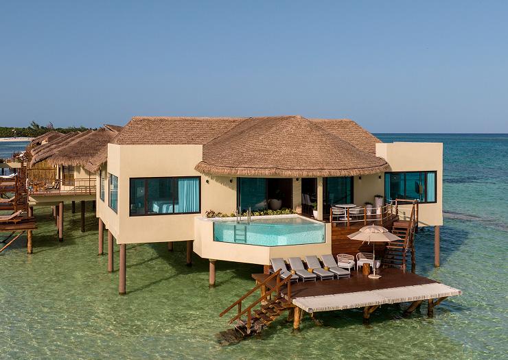 A single overwater bungalow with a glass-walled plunge pool and sun deck over the sea