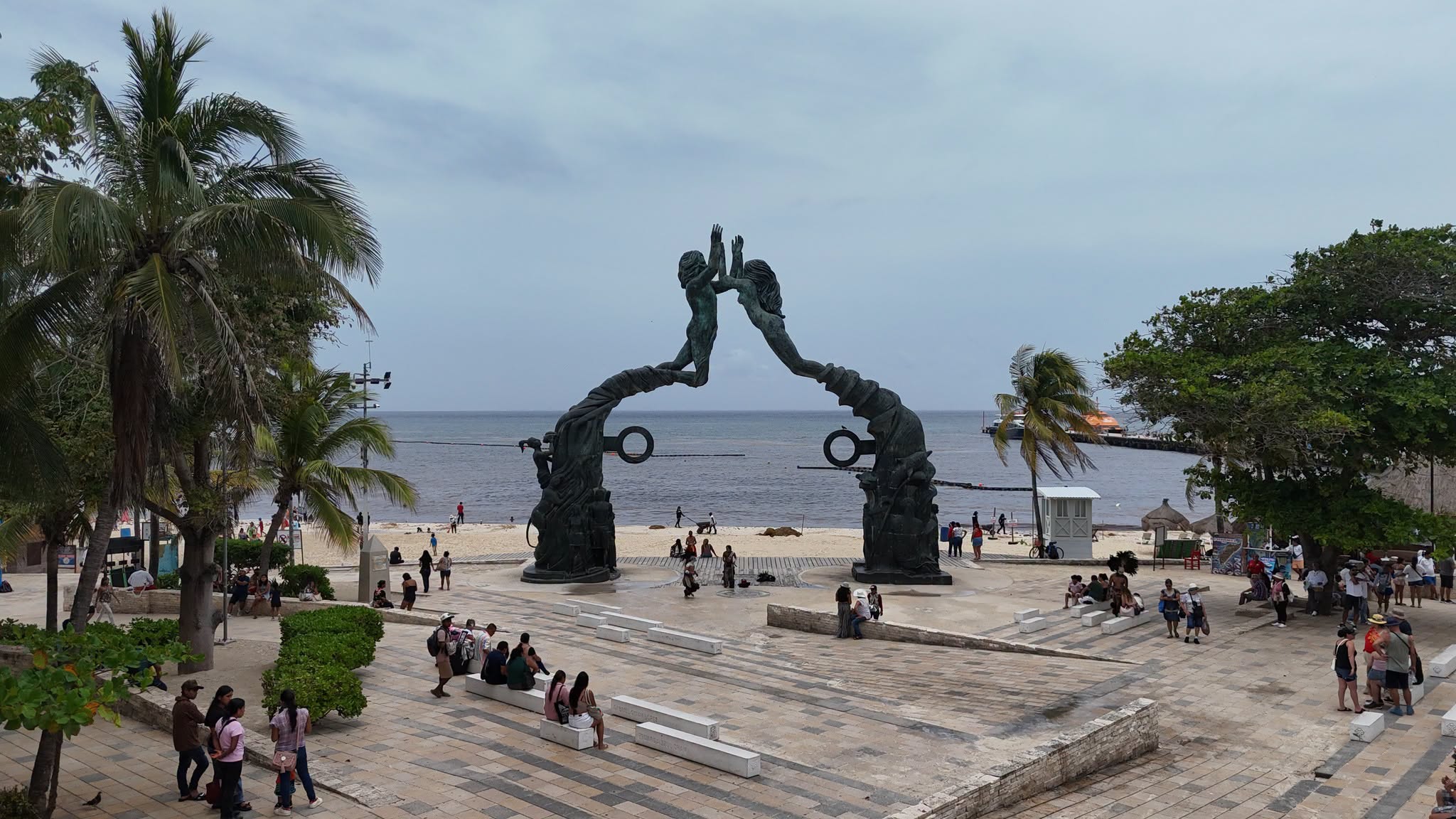 The Portal Maya bronze arch in Parque Fundadores, with the sea behind