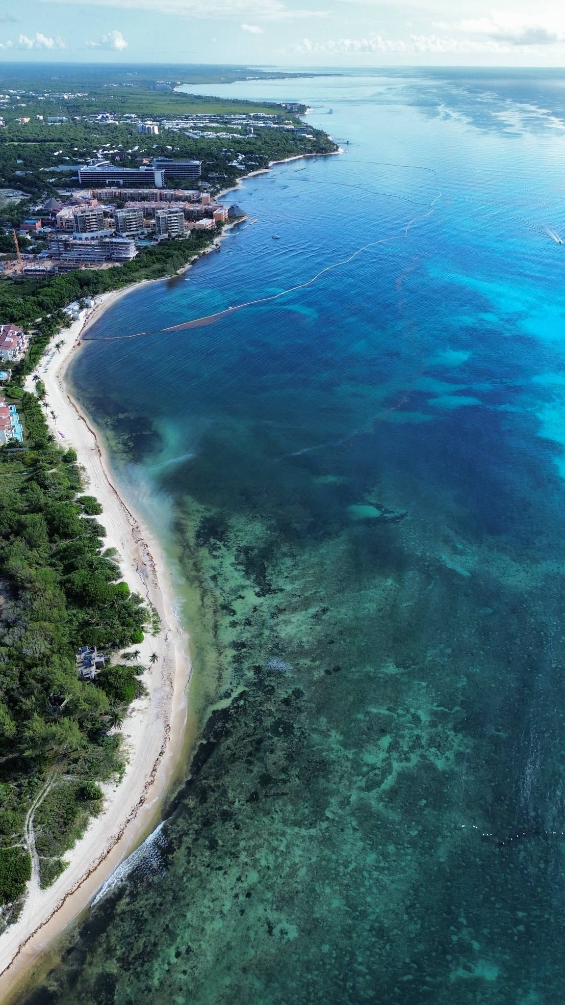 Aerial view of the Playa del Carmen shoreline between Playa Cisne and Calle 72 on September 25, 2026, with the containment barrier offshore and discoloured water along the shore